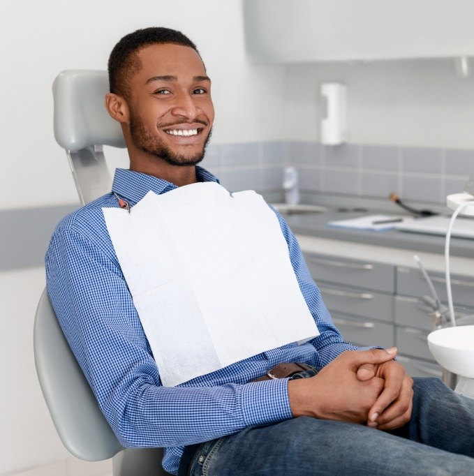 Male dental patient smiling with hands folded