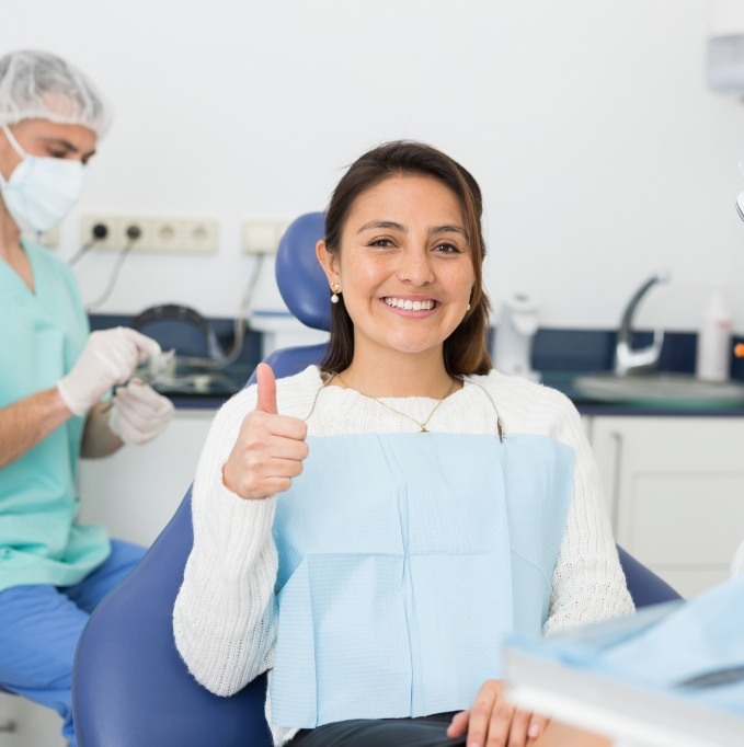 Female dental patient giving a thumbs up