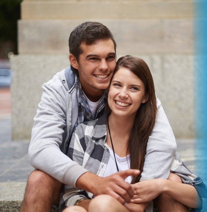 Man and woman sitting outside and hugging