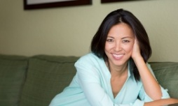 Woman on couch leaning and smiling