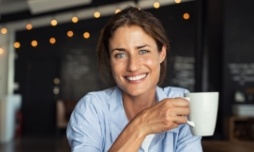 Woman smiling with a cup of coffee