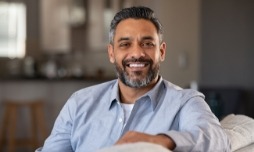 Bearded man sitting on couch and smiling