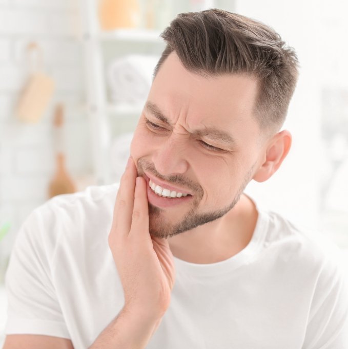 Male dental patient in white shirt with tooth pain