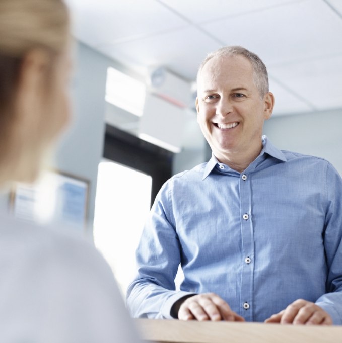 Man in button up shirt smiling