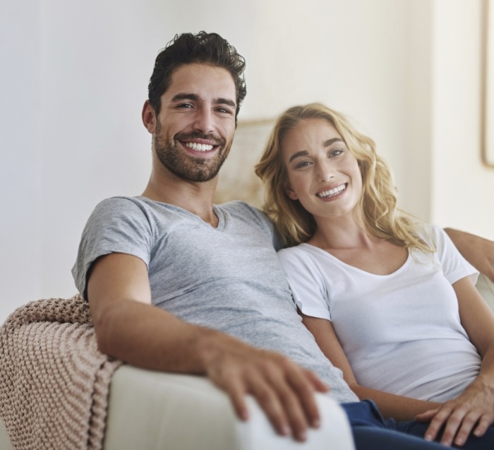 Man and woman leaning back in chair and smiling