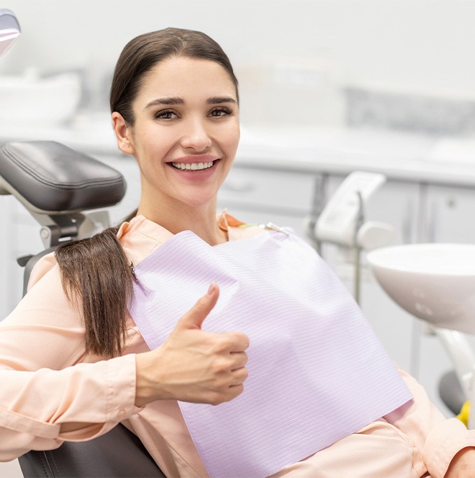Female dental patient giving a thumbs up