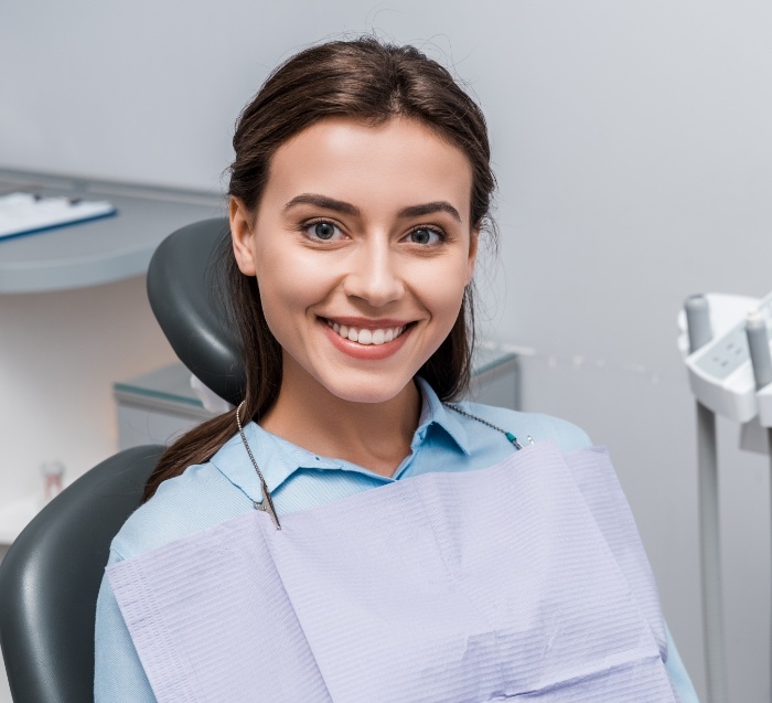 Woman sitting in dental chair and smiling