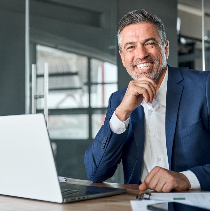 Man sitting at a desk while smiling