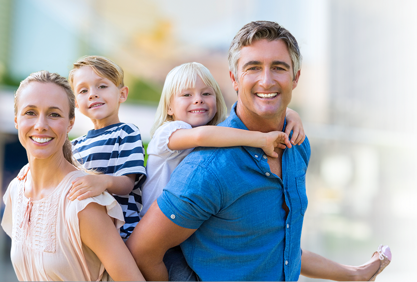 Man and woman giving kids a piggyback ride