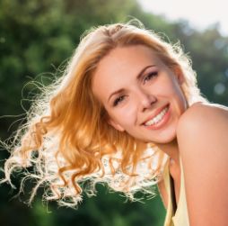 Blonde woman smiling with head tilted