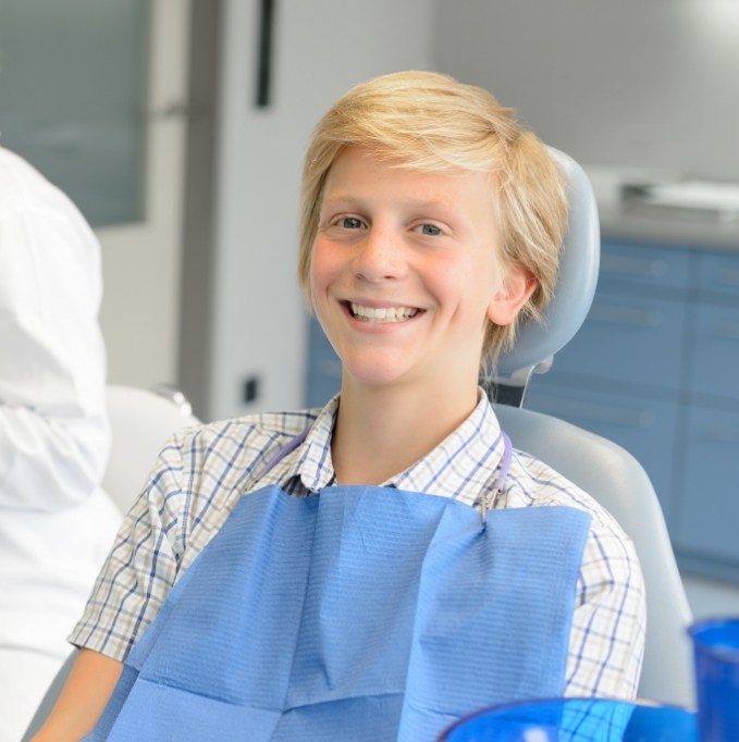 Young boy sitting in dental chair and smiling