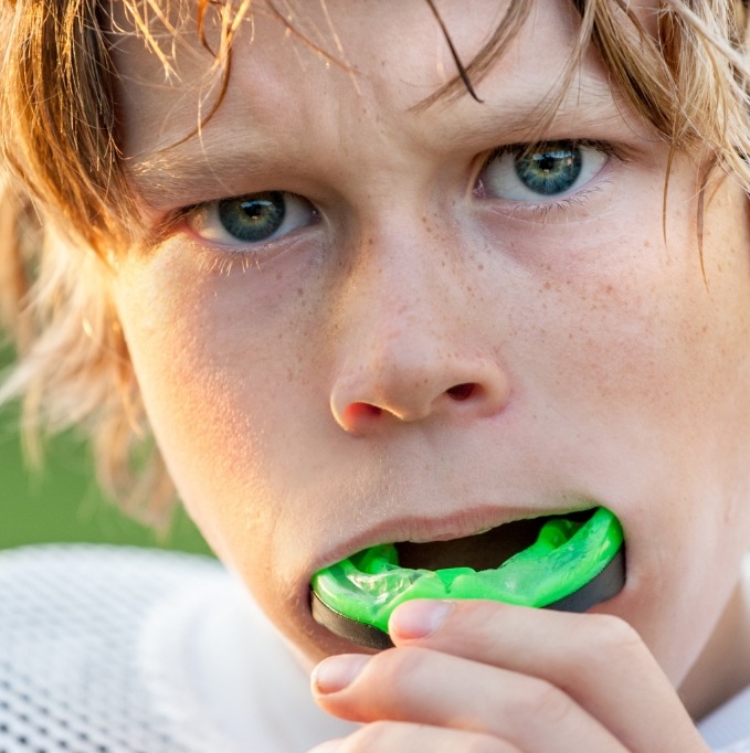 Young boy putting in a mouthguard