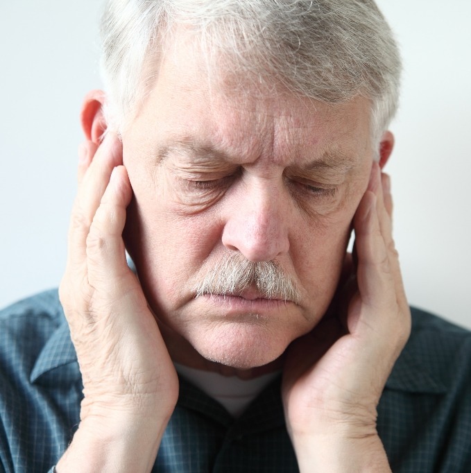 Man with eyes closed feeling his jaw joints